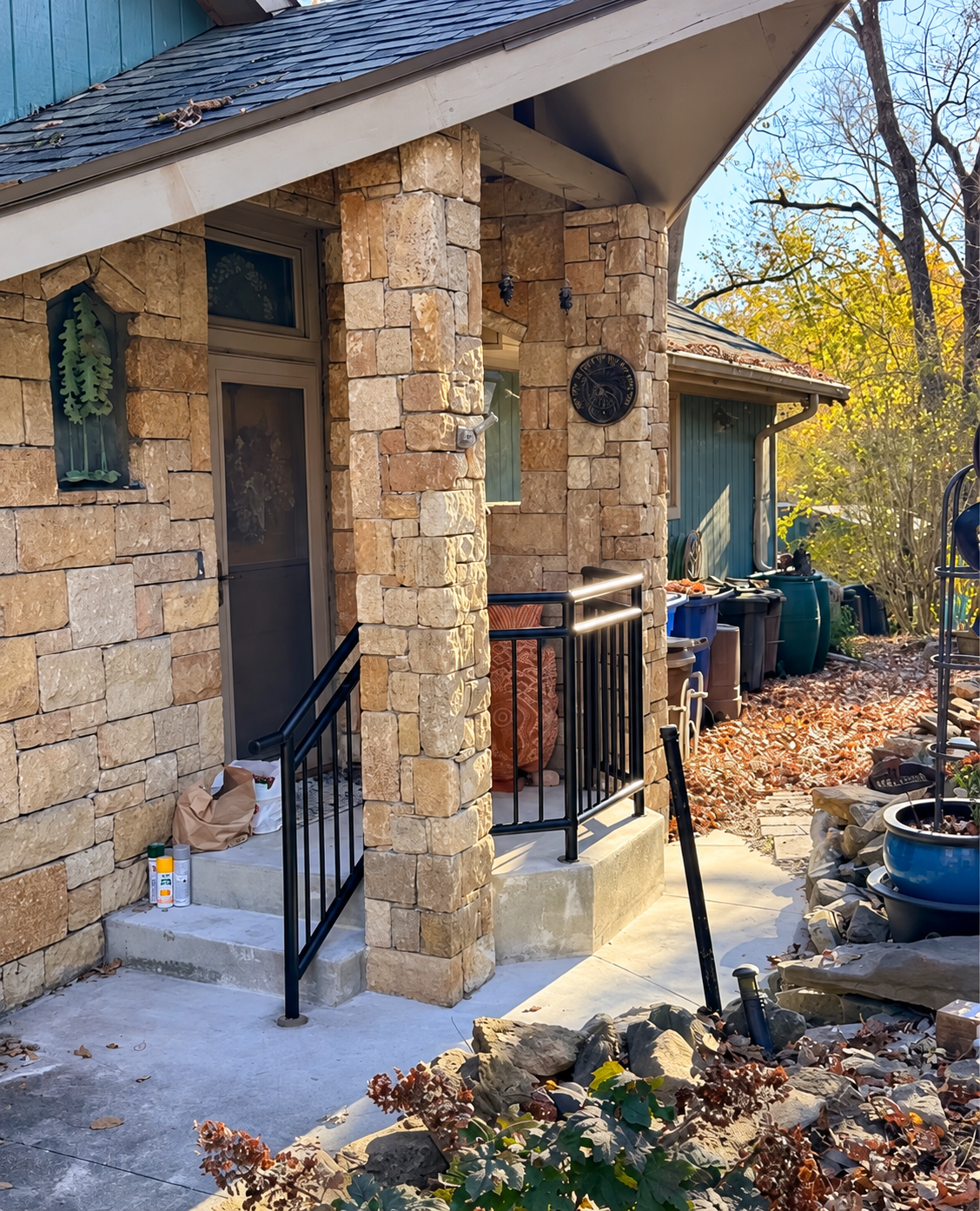 Black steel railings fitted around a stone porch and entry steps
